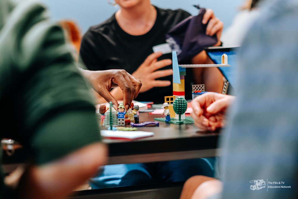 hands placing lego figurines on a table