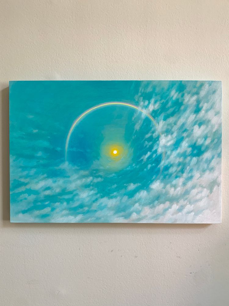 A rectangular painting against a white wall. The painting depicts a blue sky full of warping clouds and a sun sits in the center surrounded by a rainbow