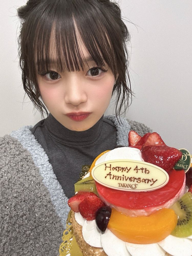 [Photo of Madopi holding the group's anniversary cake.]
