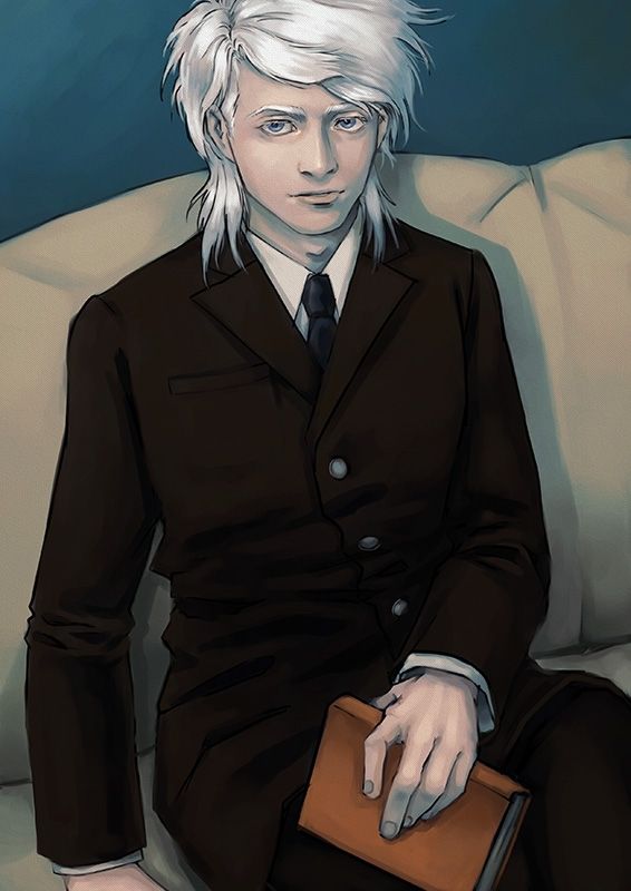 A white haired, young looking man in a brown suit sitting on a sofa. He looks conten and holds a book over his lap