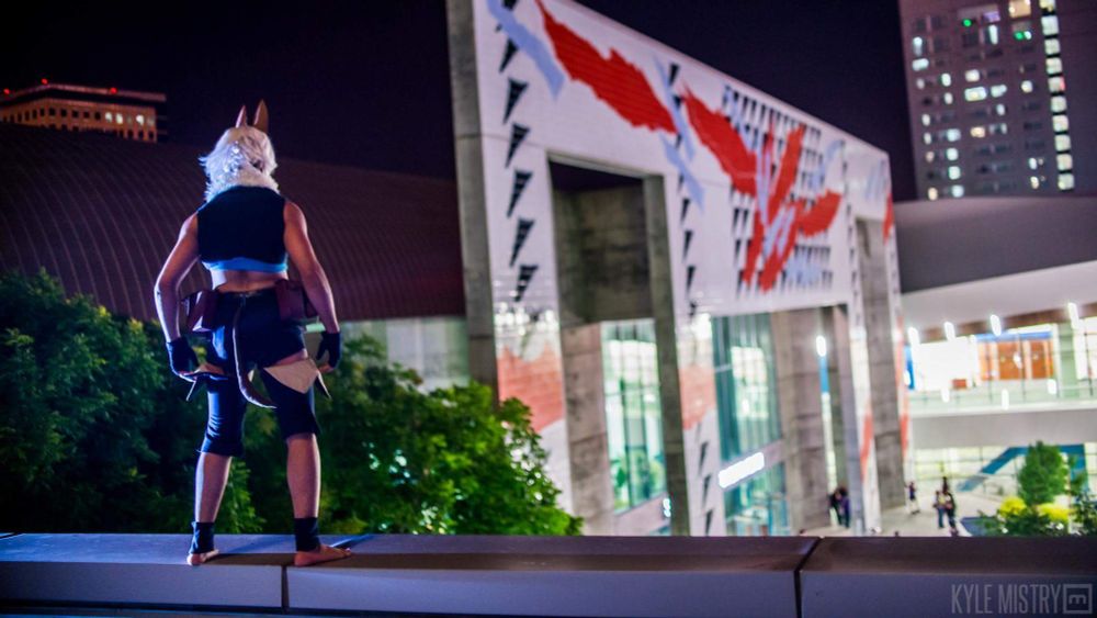 Maguma cosplaying as Ms. Fortune from Skullgirls, standing on the edge of a roof overlooking a large courtyard.