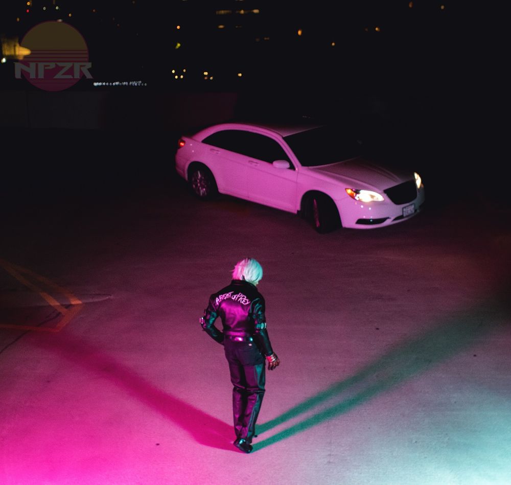 A photo of Maguma cosplaying as K' from KOF, walking back towards a white car at night, composed in the style of the Akira promotional image of Kaneda walking to his motorcycle, photo taken by NPZR