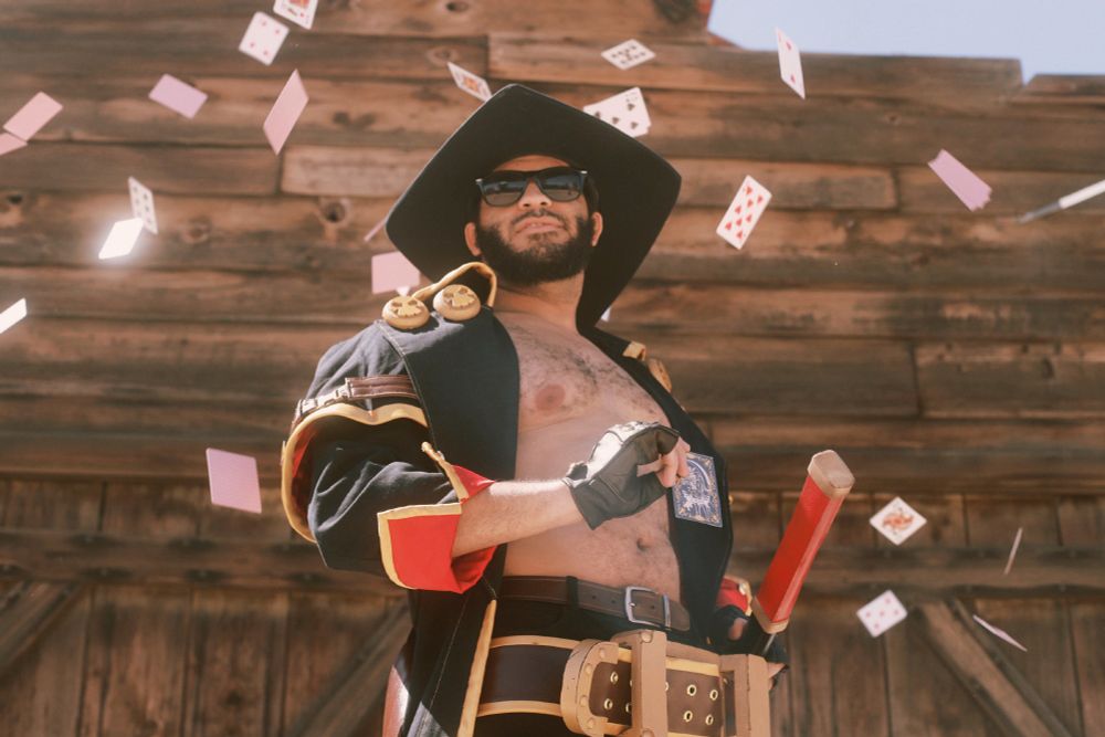 Photo of Maguma cosplaying as Johnny from Guilty Gear Strive, surrounded by falling playing cards. Photo by extranoodlesco