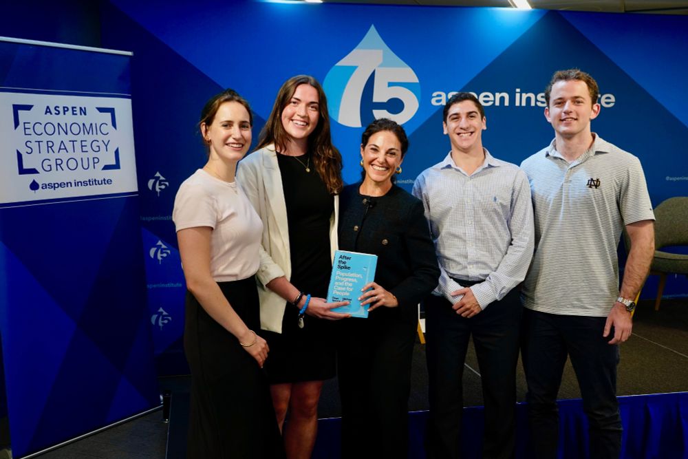 Notre Dame professor with four undergraduates holding a book at Aspen Economic Strategy Group event.