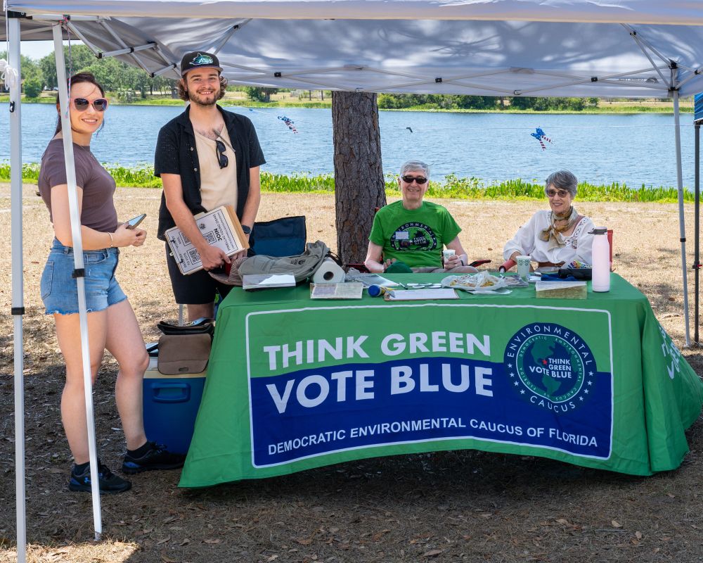 Volunteers from the Democratic Environmental Caucus welcome guests by the water.
