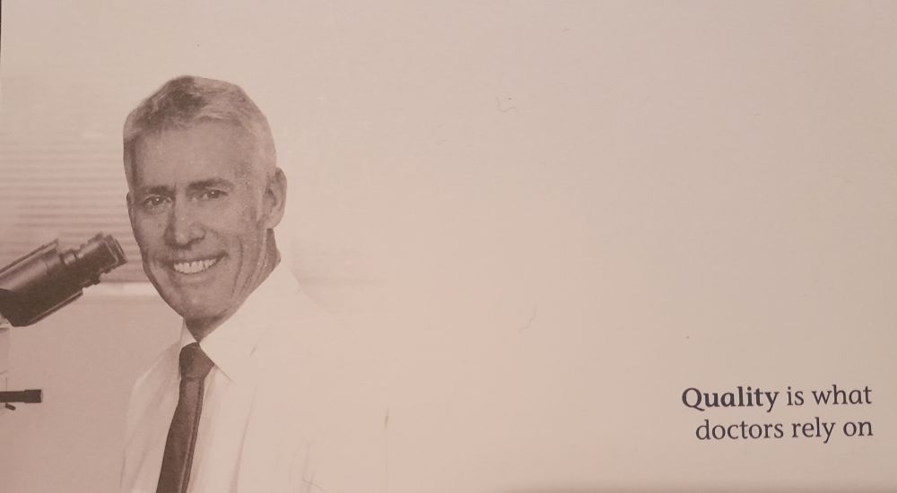 White guy with a tie and microscope. Text: "Quality is what doctors rely on"