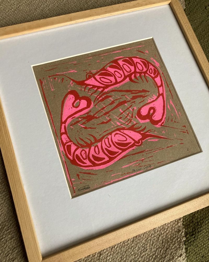 A farmed, 2 colour linoprint in red on fluoroescent pink of 2 shrimp circling each other.