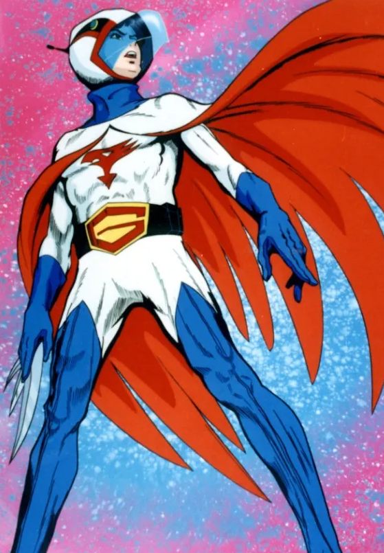 Gatchaman leader Ken Washio standing with his Gatchaman outfit that is red, white and blue. A red and white cape is flowing behind him. 