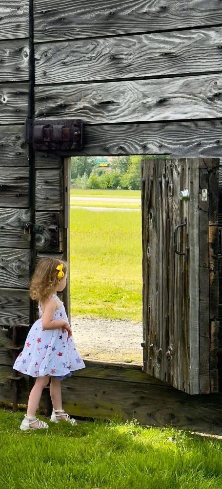 Girl looks out of postern gate at historic reconstructed fort