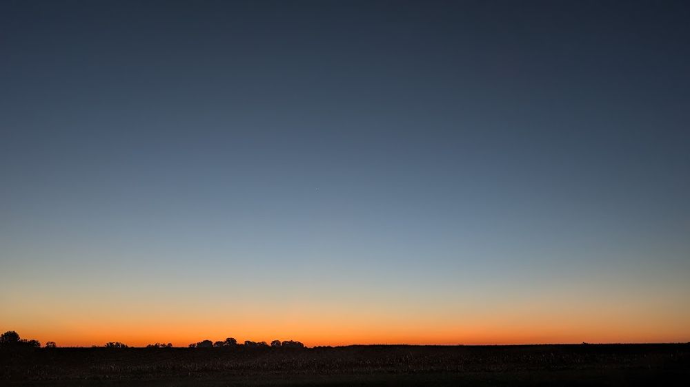 View of the sunrise, over a freshly harvested field past my backyard.
