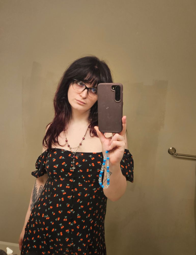 white woman selfie, she is wearing cute glasses, a pink necklace and a black and red cherry print dress!!!