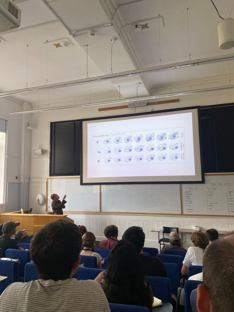 robert hawkins presenting his work on a large screen at the front of a lecture hall