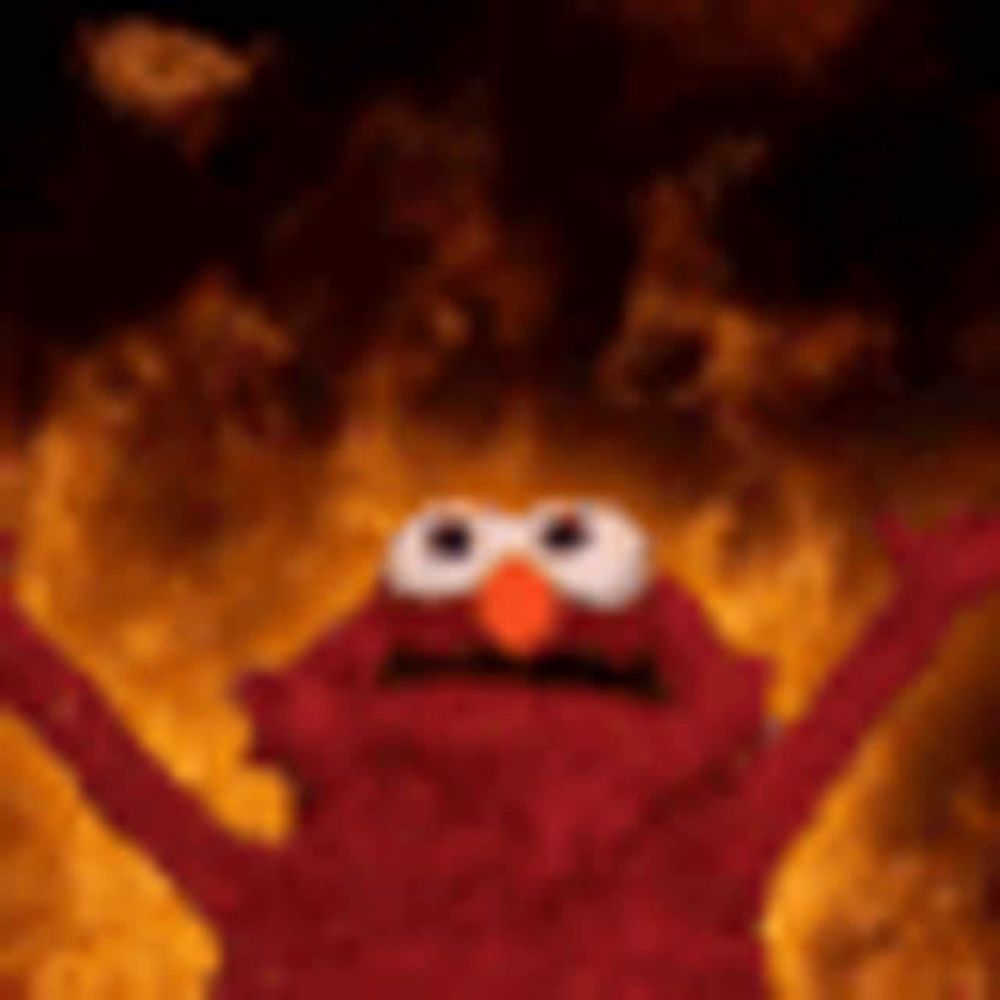 elmo from sesame street is on fire with his arms in the air .