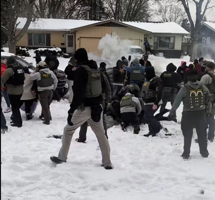 Federal agents tackle a person to the ground in the snow on Maple Lane in Elgin, IL, as gas billows in the background. 