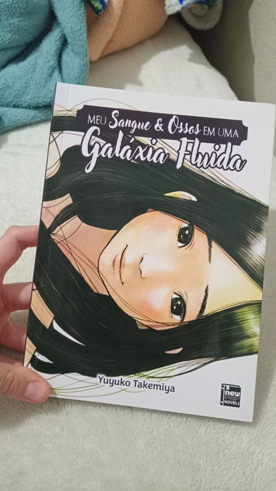 Foto da capa da light novel "Meu Sangue e Osso em uma Galáxia Fluida" de Yuyuko Takemiya. Capa ilustrada com um rosto de uma boneca anime desenhada pelo Inio Asano.