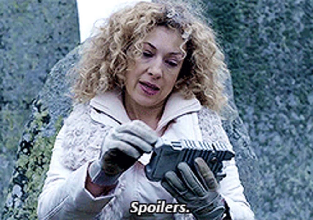 a woman in a white jacket and gloves is holding a piece of paper that says spoilers .