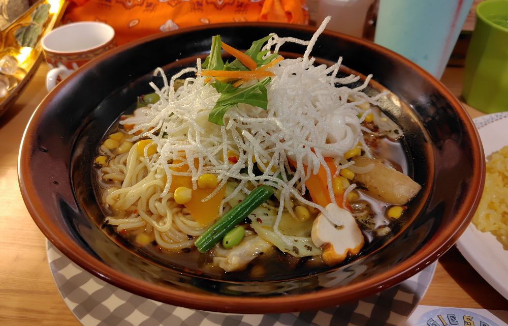 スープカレー「ミクばーぐ」単品の写真です。野菜もりもりのスープカレーにトッピングの蒸しめん、あとはハンバーグが入ってます。手のひらサイズくらいの大きなハンバーグなのですが、野菜がもりもりすぎて全然見えません。