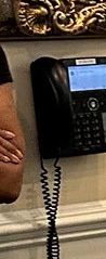 a phone and the very edge of a black? woman's fingers and arm