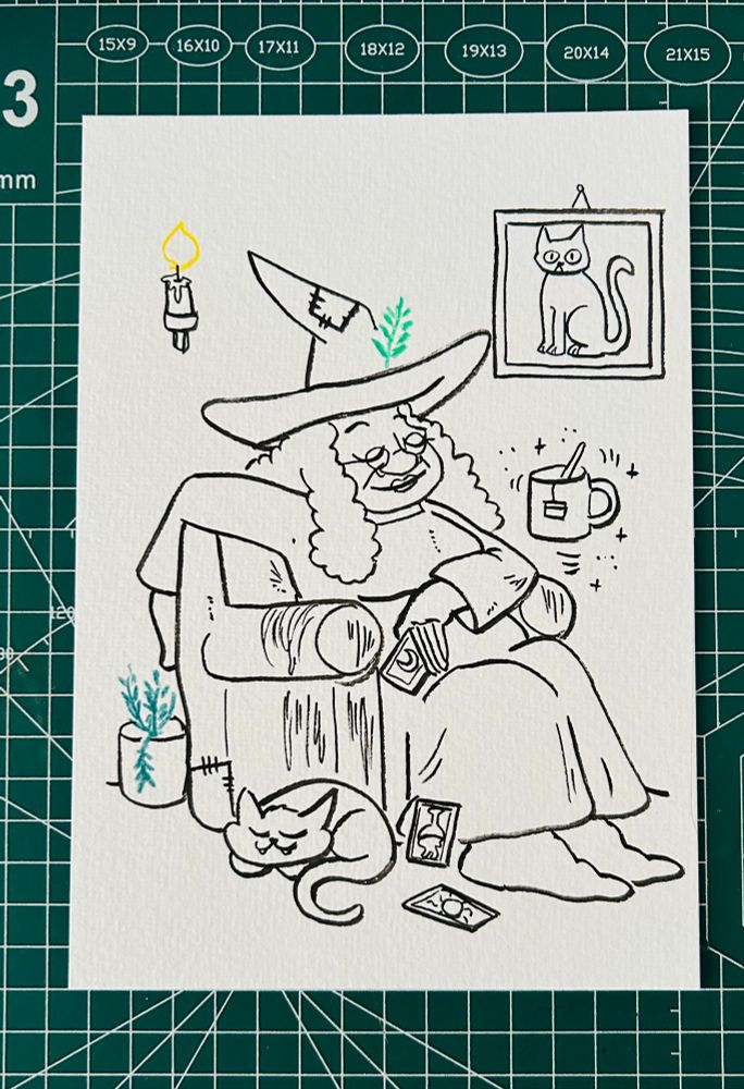 Foto: eine schwarz weiß Zeichnung auf Aquarellpapier, eine Hexe ist in ihrem Sessel eingeschlafen, auf dem Boden schläft eine Katze.