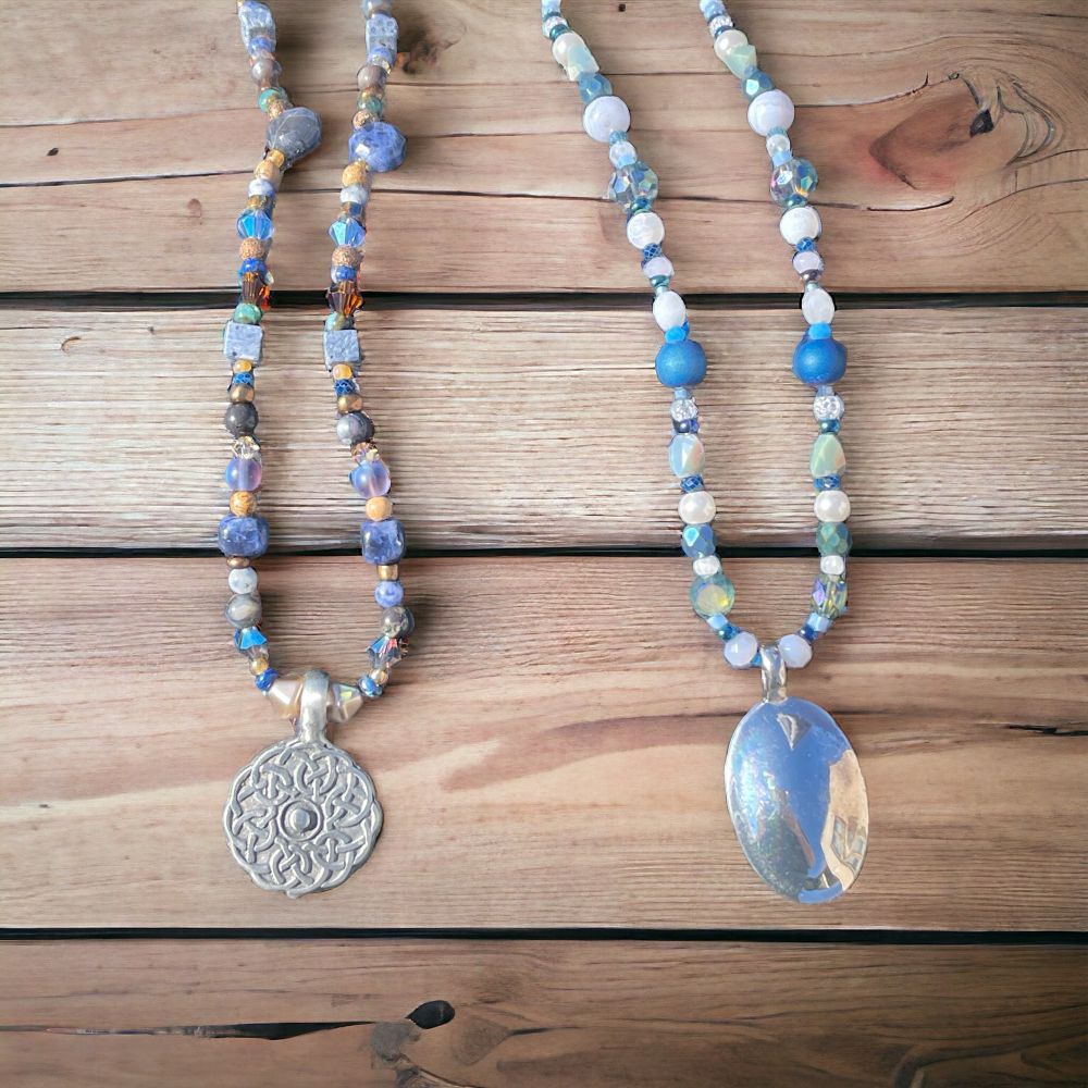 Two Silver and blue beaded necklaces on wood 