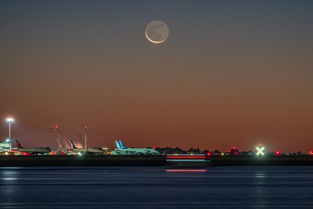 The fall equinox new moon in the morning twilight rising above Logan airport.