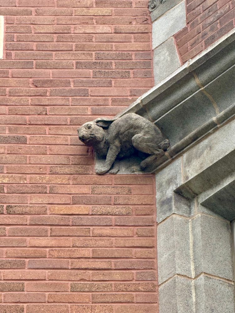 A terra cotta rabbit on a mostly brick building.