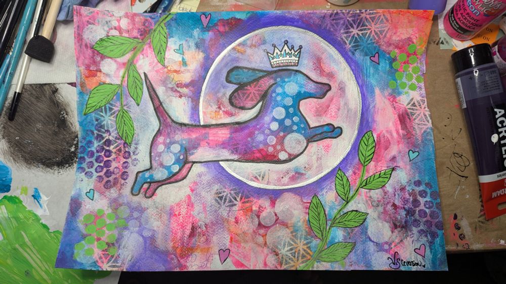 A whimsical mixed media piece of art that features a leaping dachshund with a crown on her head, tail raised happily like a waving flag.
