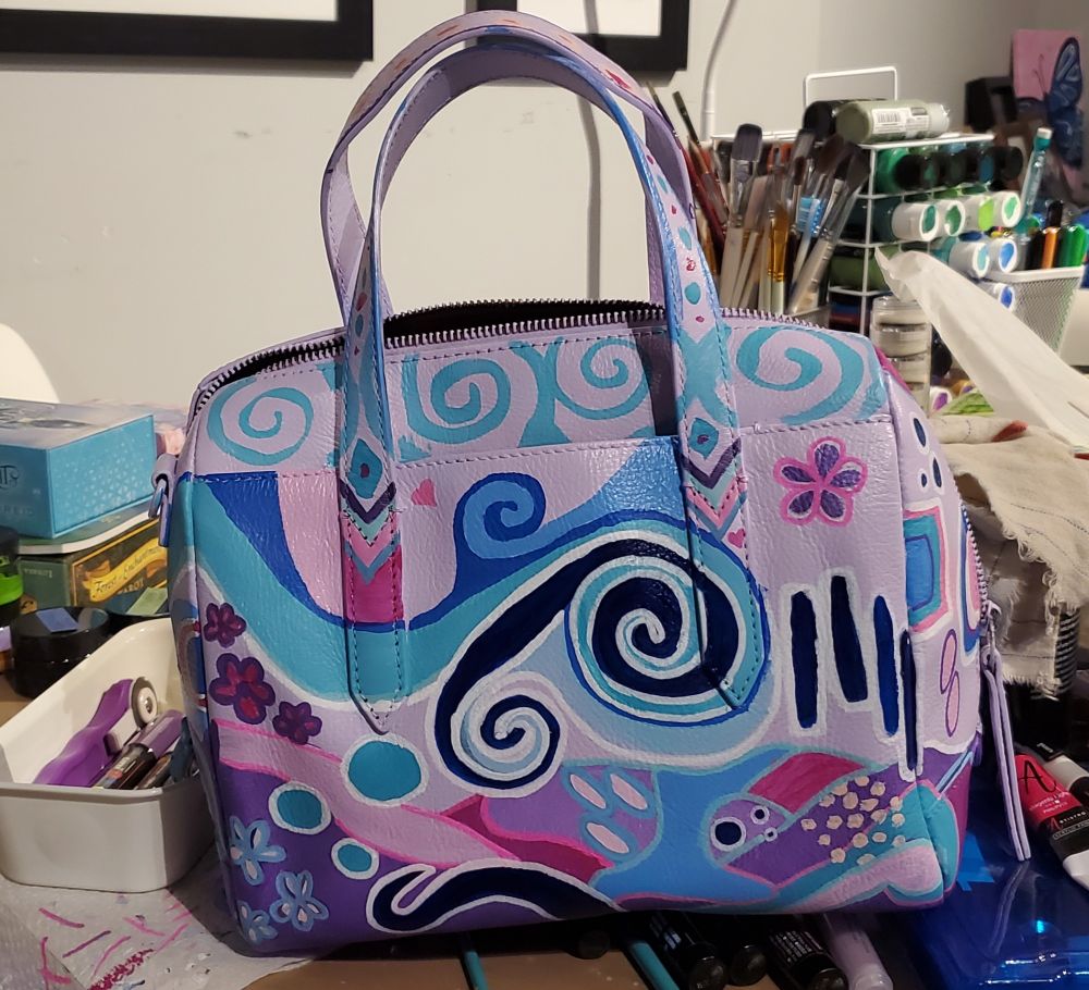 All 4 photos show different sides of the same purse. The purse has been painted in many random abstract shapes in various colours 