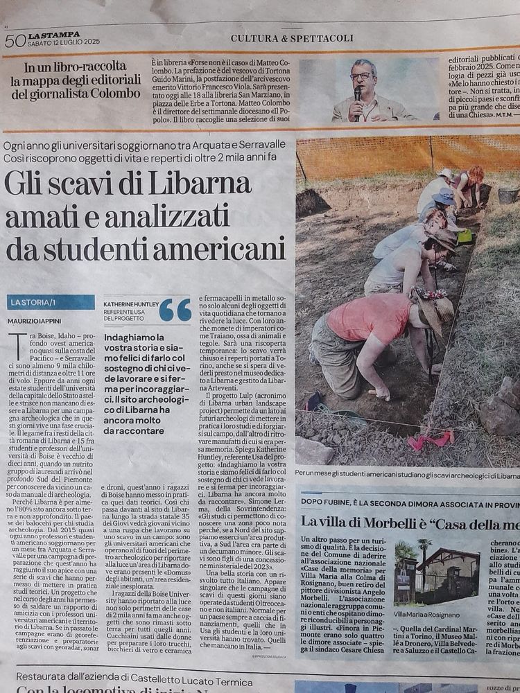 Photo of a newspaper article. It includes a photo of students excavating in a trenchThe text reads: Ogni anno gli universitari soggiornano tra Arquata e Serravalle
Così riscoprono oggetti di vita e reperti di oltre 2 mila anni fa
Gli scavi di Libarna amati e analizzati da studenti americani. 

MAURIZIO IAPPINI
Tra Boise, Idaho - profondo ovest americano quasi sulla costa del
Pacifico - e Serravalle
ci sono almeno 9 mila chilometri di distanza e oltre 11 ore di volo. Eppure da anni ogni estate studenti dell'universita
della capitale dello Stato a stelle estrisce non mancano di essere a Libarna per una campagna archeologica che in questi giorni vive una fase crucia-le. Illegame frai resti della città romana di Libarna e 15 fra studenti e professori dell'università di Boise è vecchio di dieci anni, quando un nutrito gruppo di laureandi arrivò nel profondo Sud del Piemonte per conoscere da vicino un caso da manuale di archeologia.
Perché Libarna è per almeno 1 80% sito ancora sotto terra e non approfondito. Il paese dei balocchi per chi studia archeologia.
Dal 2015 quasi ogni anno professori e studenti americano soggiornano per un mese fra Arquata e Serravalle per una campagna di preparazione che quest'anno ha raggiunto il suo apice con una serie di scavi che hanno permesso di mettere in pratica studi teorici. Un progetto che nel corso degli anni ha permesso di saldare un rapporto di amicizia con i professori universitari americani eil territorio di Libarna. Se in passato le campagne erano di georeferenziazione e preparatorie agli scavi con georadar, sonar e droni, quest'anno i ragazzi di Boise hanno messo in pratica quei dati teorici. Così chi passa davanti al sito di Libarna lungo la strada statale 35 dei Giovi vedrà giovani vicino a una ruspa che lavorano su uno scavo in un campo: sono gli universitari americani che operano al di fuori del perimetro archeologico per riportare alla luce un area di Libarna dove erano presenti le «Domus»
degliabitanti, un'area residenzi…