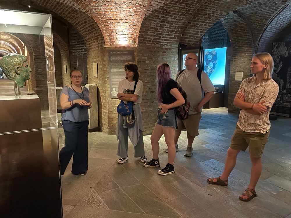 A group of students gather round an Augustan era bronze bust of a man