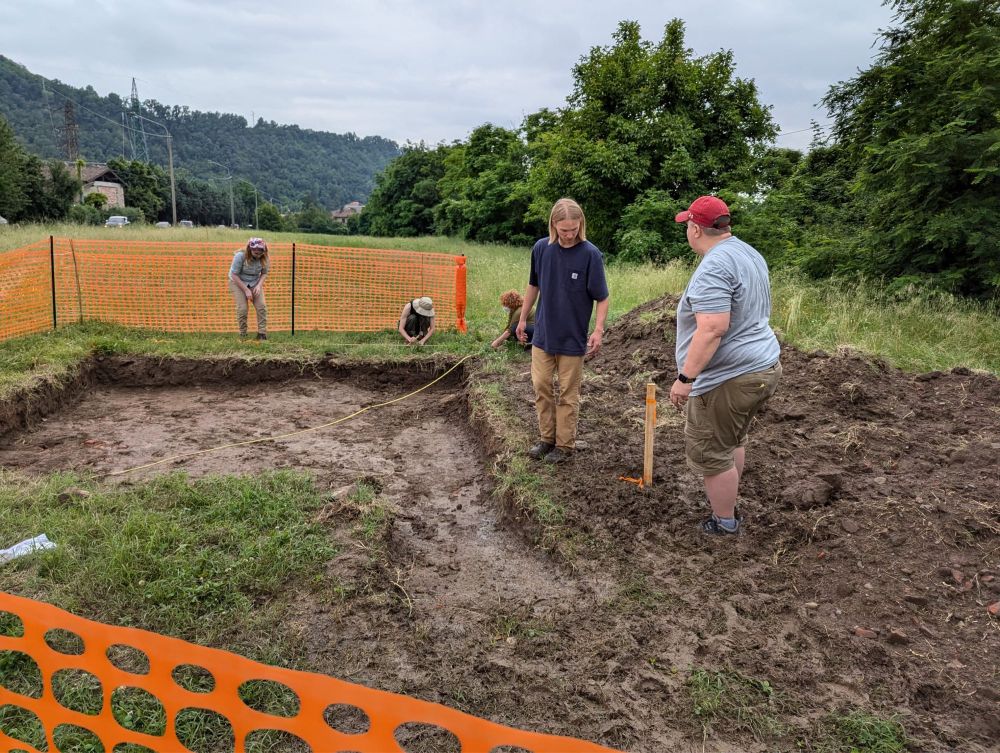 A group of students gridding out a trench.