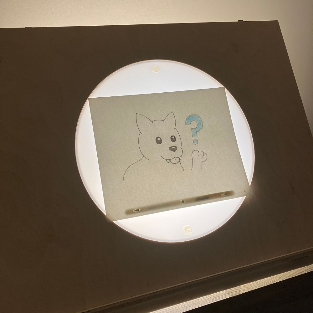 a photo of an animation light box with a piece of paper that has a wolf pupy drawn on it