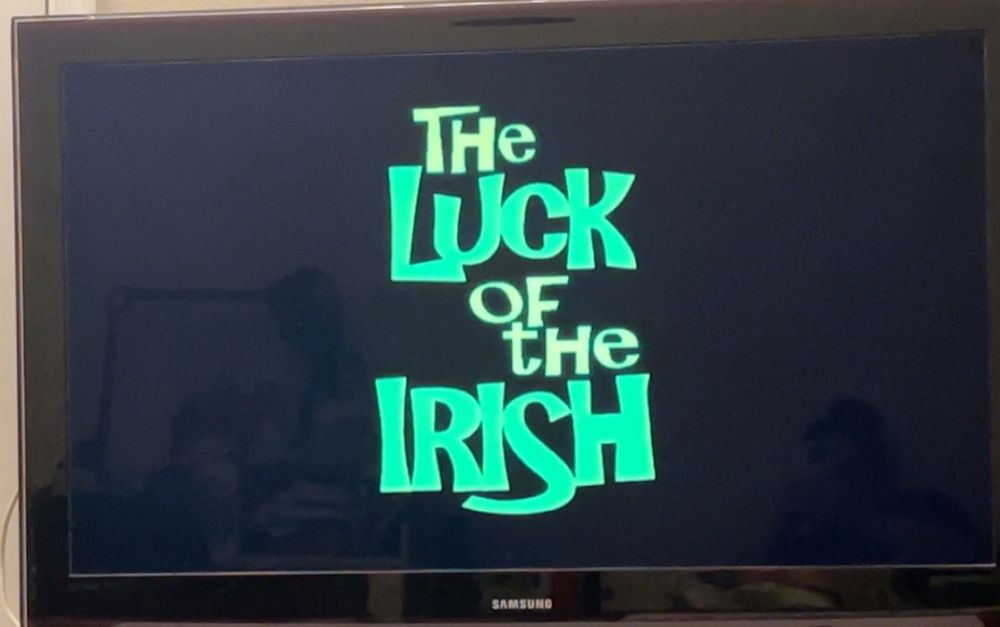 A black tv screen with the title card of Disney Channel Original Movie “The Luck of the Irish” on it in green font. 