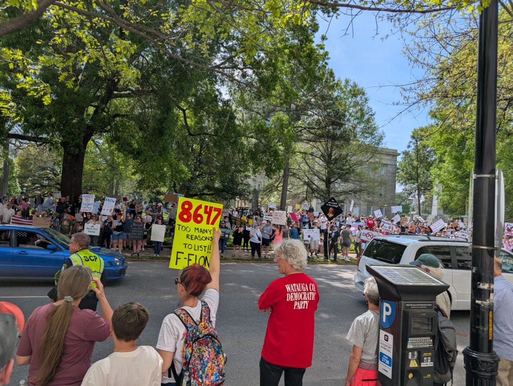 Crowds in front of the legislature showing signs to passing cars
