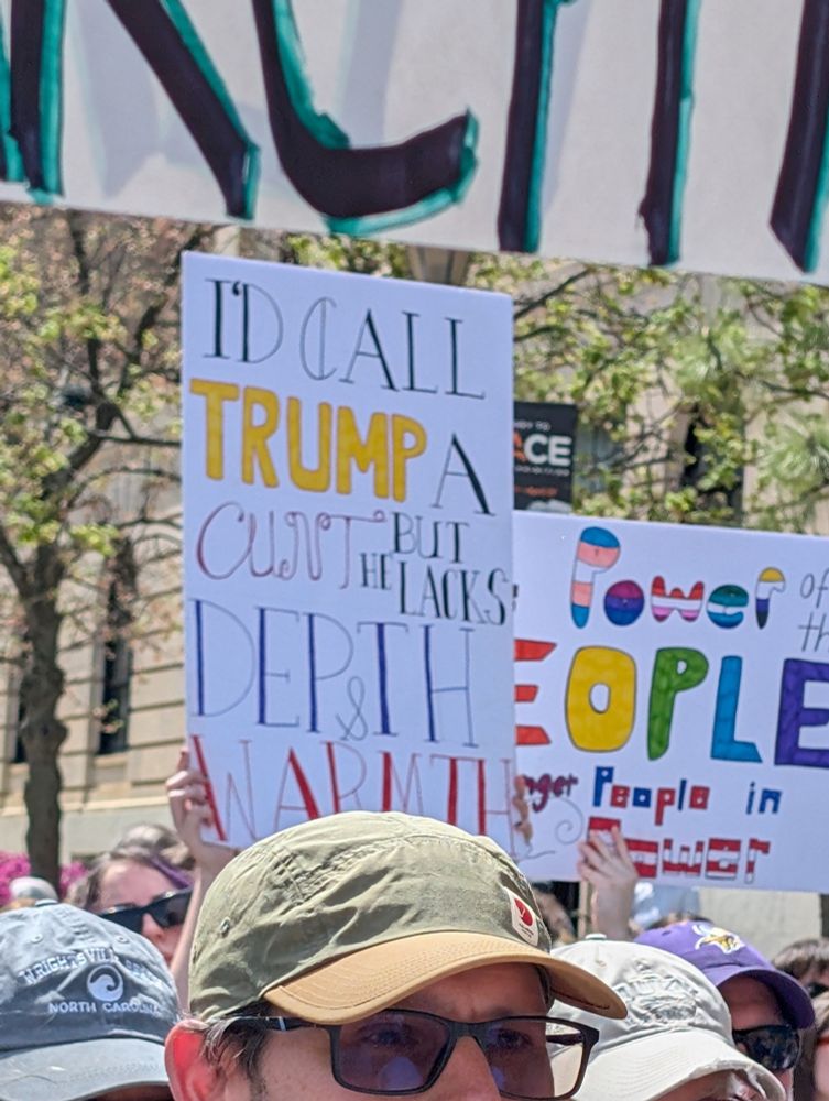 Protest sign that reads "I'd call trump a cunt but he lacks depth & warmth"