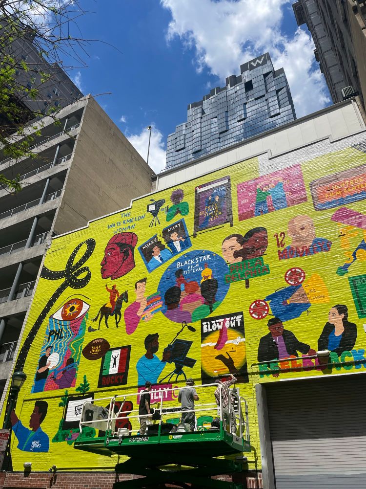 Colorful mural in process featuring Philly-flavored films such as Silver Linings Playbook and Trading Places as well as Philadelphia Story. On Sansome back stage entrance of Philadelphia Film Society. 