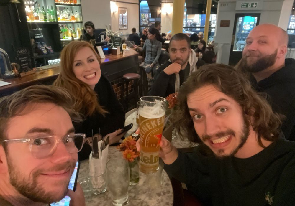 Our first London Pub! Also where I had my first Heineken (not that bad) and where Mr. Fruit had his first bangers and mash (he was not blown away) 

However you can see Mr. Fruit playing Pokémon pocket, we were ripping packs at the table and were successfully able to get everyone else at the table playing, only for Danielle to open only a couple packs and immediately get the coolest chase cards in the game without even trying. By the end of the trip her pull luck was so insane I thought she was cheating or just paying off the pokegods. Turns out my pulls were just ass.