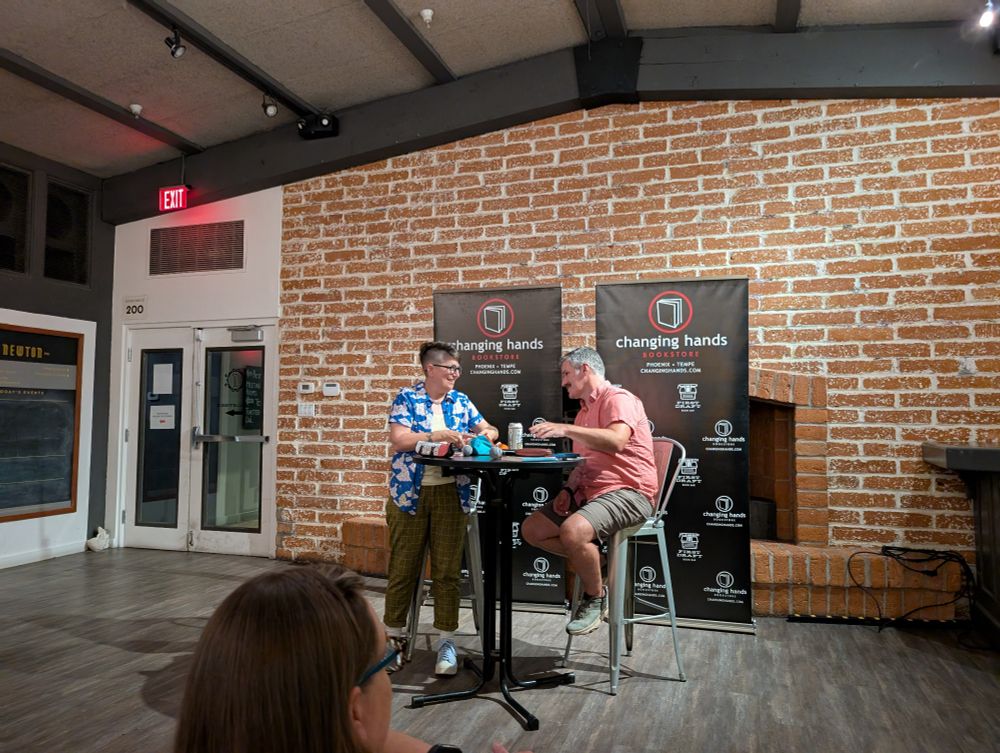 Annalee Newitz with Matt Bell at a raised table at Changing Hands bookstore.