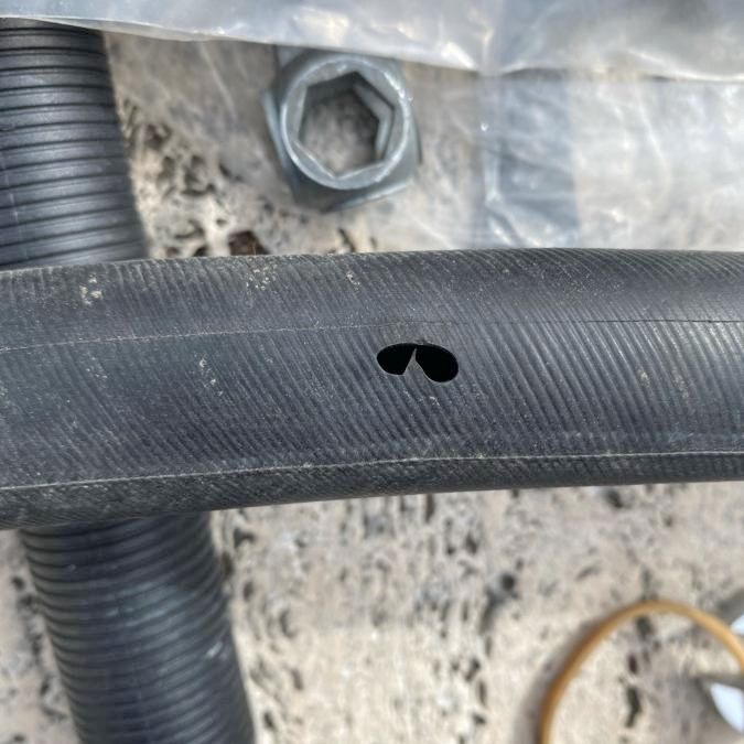 A black rubber bicycle tyre with a strange hole shaped like the outline of a pair of sunglasses, or eyes.