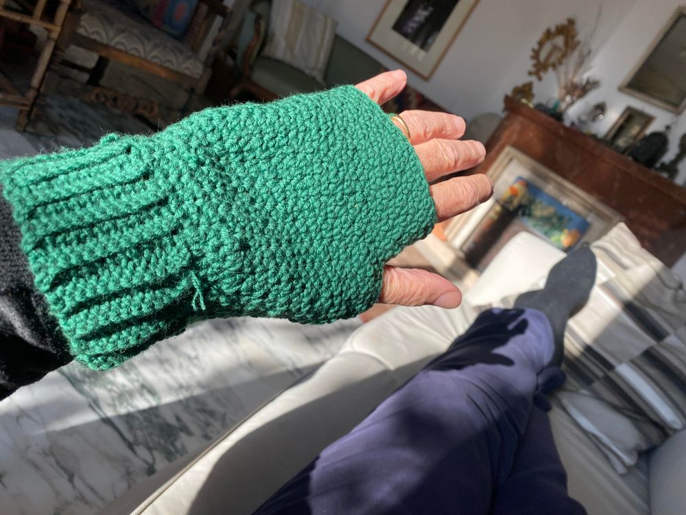 A green fingerless mitt crocheted in griddle stitch. 