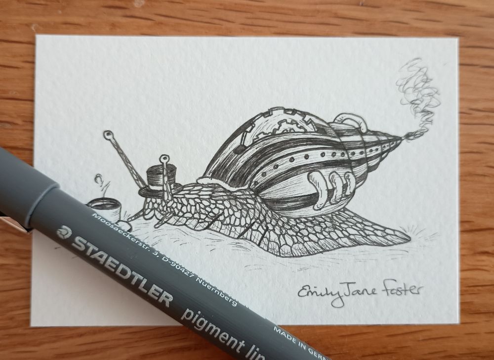 A photograph of a Staedtler 0.05mm pigment liner pen resting on an ACEO sized black and white illustration of a steampunk snail in a top hat. A cup of tea is just visible by the pen. The shell is striped and has pipes, cogs and rivets visible. Signed by Emily Jane Foster.