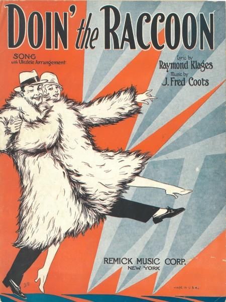 Sheet music cover for "Doin’ The Raccoon" by Raymond Klages and J. Fred Coots (1928). Jagged red and blue background with a black and white illustration of a man and woman in front. They are both wearing fashionable hats and huge, calf-length raccoon-fur coats with high rolled collars. The man is immediately behind the woman as they high kick from left to right, lifting her slightly off the ground and holding her right hand in what could be an anatomically implausible position, or might be fine under all that fur. It's hard to tell.