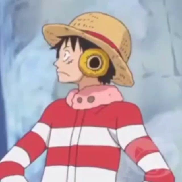 luffy from one piece is wearing a straw hat and headphones and a striped shirt .