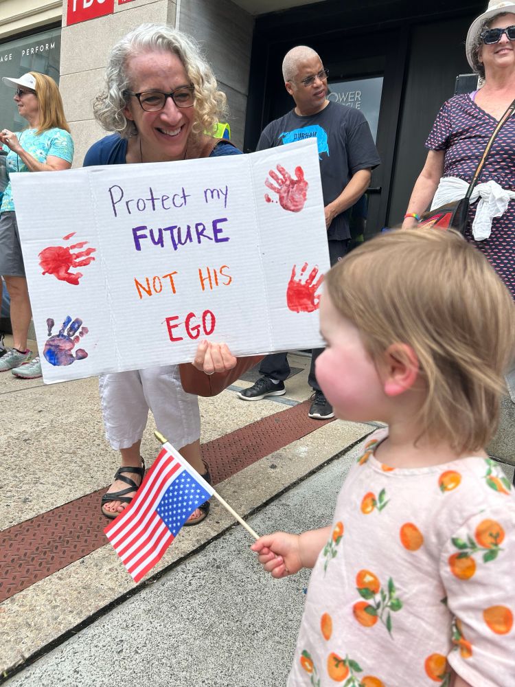 Sign in front of toddler that says “protect my future, not his ego”