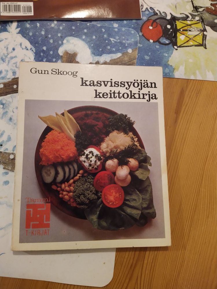 Gun Skoogin kirjoittama Kasvissyöjän keittokirja -niminen kirja pöydällä. Kannessa erilaisia kasviksia aseteltuna lautaselle. 