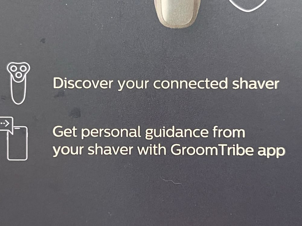 Text on a black background card reading “Discover your connected shaver” and “Get personal guidance from your shaver with GroomTribe app”
