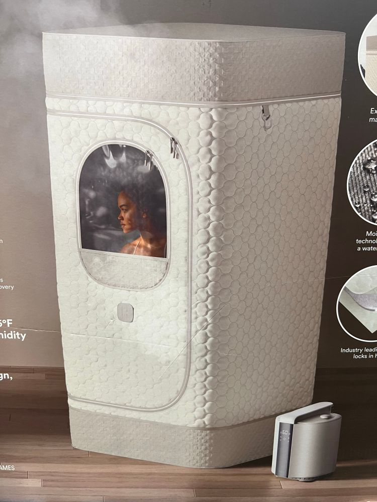 A personal sauna product photo with a person zipped inside of it