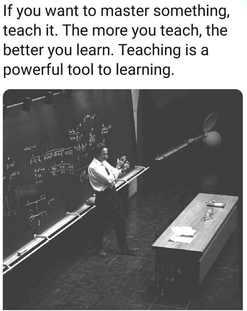 A photo of a teacher with a blackboard in the background. The essence: Teaching is one of the best means of learning.
