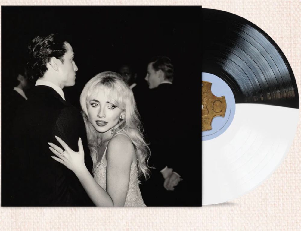 A black-and-white photo of Sabrina carpenter with long blonde hair in a glamorous dress dancing with a man in a suit. The image is on the cover of a vinyl record, partially visible beside it.