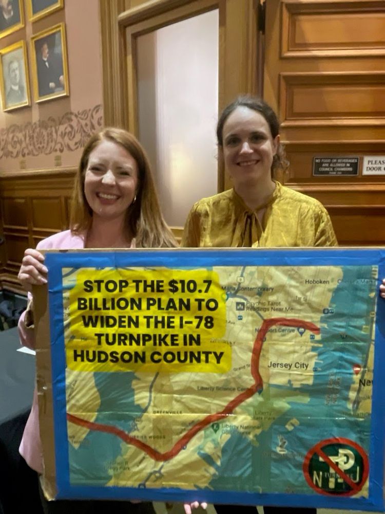 Katie Brennan and Eleana Little hold a sign that says “STOP THE $10.7
BILLION PLAN TO WIDEN THE I-78
TURNPIKE IN HUDSON COUNTY”